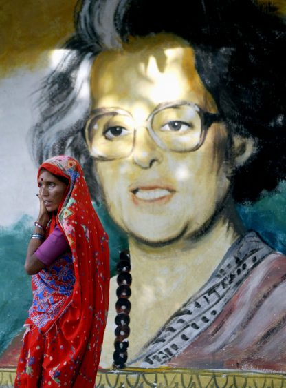 A woman passes a painting of former Indian prime Minister Indira Gandhi in Calcutta May 13, 2004. Italian-born Sonia Gandhi, daughter-in-law of Indira Gandhi who was assassinated in 1984, is expected to lead the Congress party into power in India after a surprisingly good show in the country's federal election. REUTERS/Jayanta Shaw  JS/ - RTRJFIG