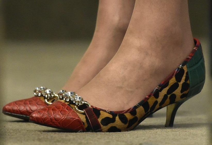 The shoes of Britain's Home Secretary Theresa May are seen as she listens to U.S. Attorney General Loretta Lynch speak at a 'Countering Terrorism: A Global Perspective' event at Chatham House in London, Britain December 9, 2015. Lynch said on Wednesday she was disappointed by a European Union court decision to strike down a data transfer deal and said legislation in the European Parliament might further restrict information sharing. REUTERS/Toby Melville - RTX1XUYK