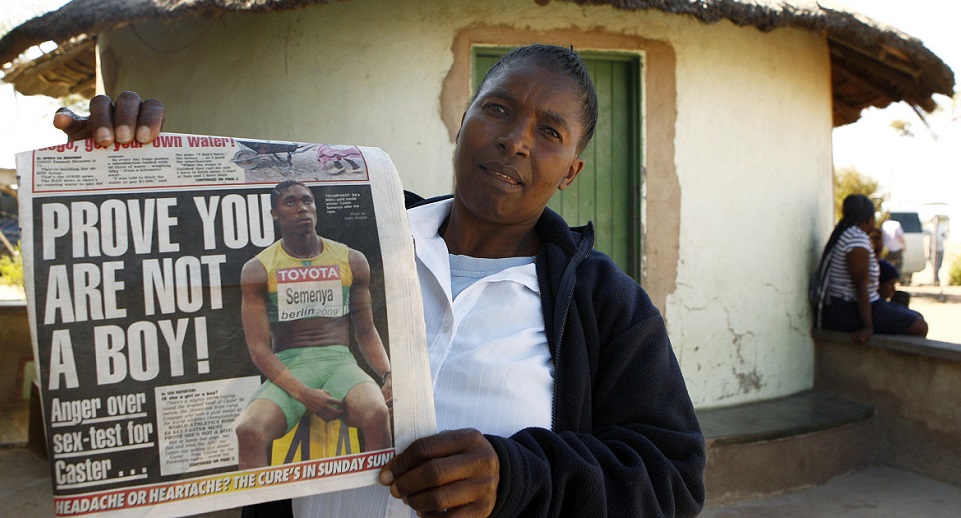 Dorcas Semenya (C), mother of South Africa's teenage 800 metres world champion Caster Semenya, displays the front page of a local newspaper at Ga-mmasehlong village outside Polokwane in the Northern province,August 21,2009. South Africa's ruling party leapt on Thursday to the defence of the world champion runner undergoing a gender verification test, saying she was the country's "golden girl" and a role model for young athletes. International Association of Athletics Federations (IAAF) General Secretary Pierre Weiss said an investigation into Semenya's gender was under way in South Africa and Berlin. Reuters/Siphiwe Sibeko (SOUTH AFRICA SPORT POLITICS IMAGES OF THE DAY) - RTR26YYB