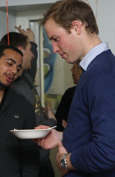 Britain's Prince William pats his stomach after eating a piece of a birthday cake during a visit to the charity Centrepoint, on the their 40th anniversary, at one of their centres in central London December 16, 2009. Centrepoint is a charity that provides housing and support to improve the lives of homeless people between the ages of 16 and 25. REUTERS/Luke MacGregor (BRITAIN - Tags: ROYALS SOCIETY ANNIVERSARY) - RTXRW78