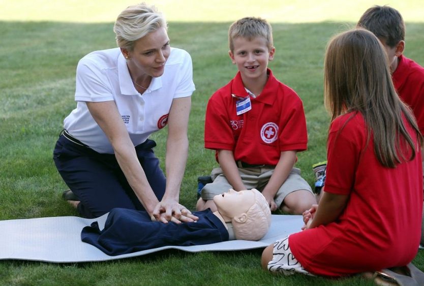 Monaco's Princess Charlene, goodwill ambassador for the IFRC for first aid, demonstrates on a dummy how to practice first aid to chidren at the UN in Geneva