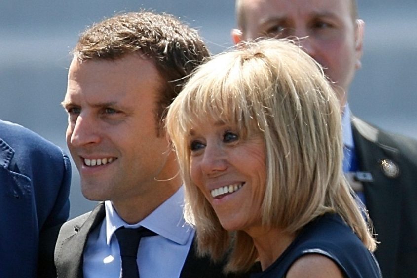 French Economy Minister Emmanuel Macron (L) and and his wife Brigitte Trogneux attend the Bastille Day military parade on the Champs-Elysees in Paris, France, July 14, 2016. REUTERS/Charles Platiau - RTSHVPR