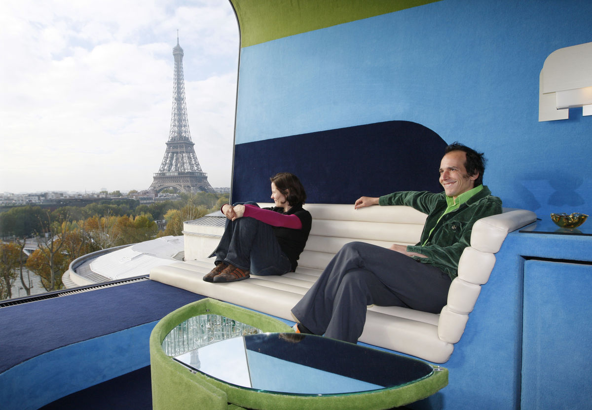Os artistas suíços Sabina Lang e Daniel Baumann sentados no "Hotel Everland", situado no telhado do Museu de Arte Contemporânea de Paris. Este hotel é uma instalação artística que consiste num único quarto decorado ao estilo dos anos 1970, com vista para a Torre Eiffel. (REUTERS/Philippe Wojazer)