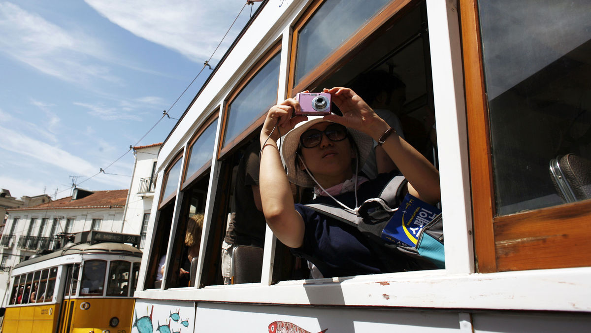 Tourist takes a picture from the Tram 28 in Lisbon