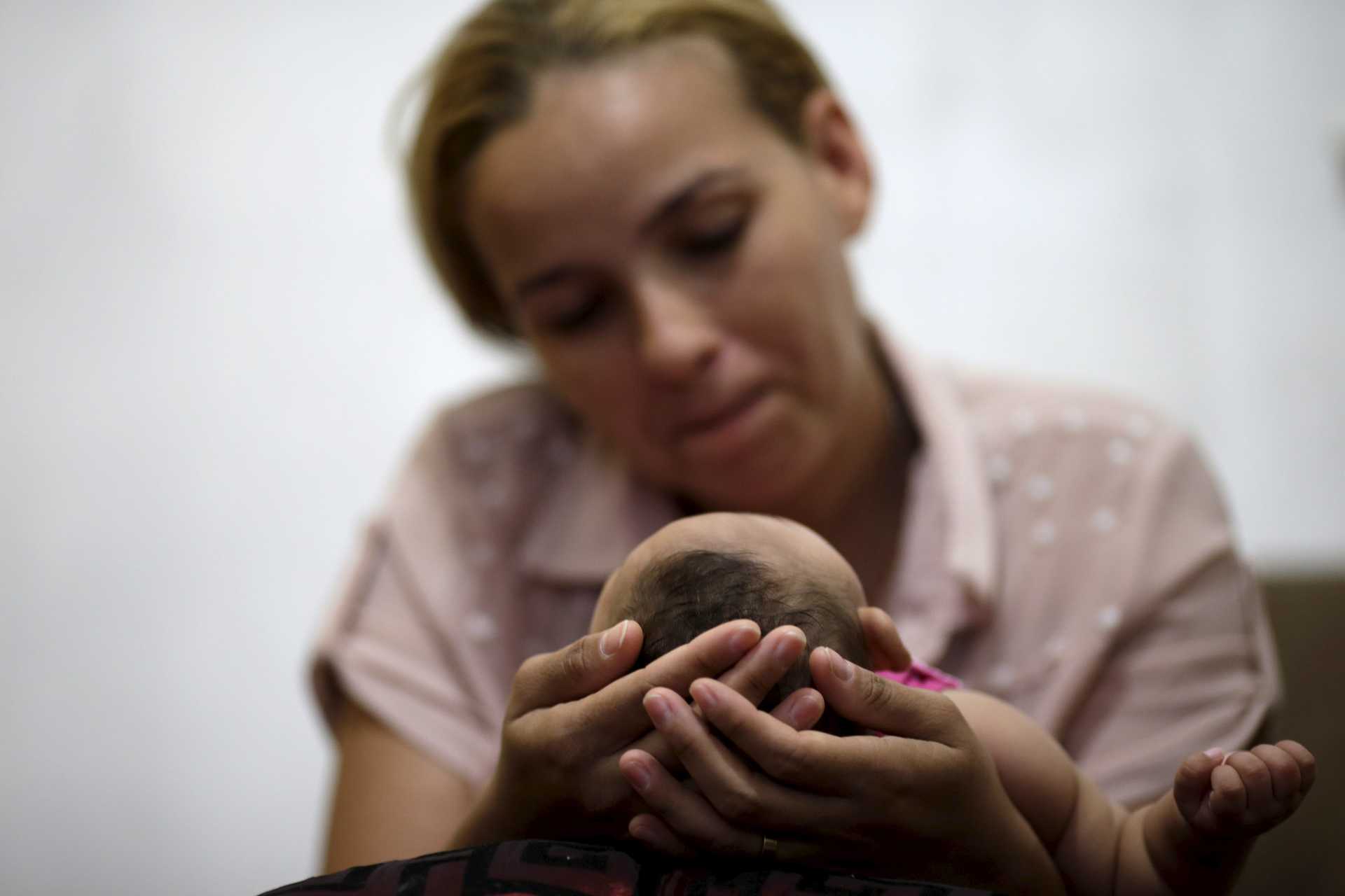 Gleyse Kelly holds the head of her daughter Maria Geovana, who has microcephaly, in Recife