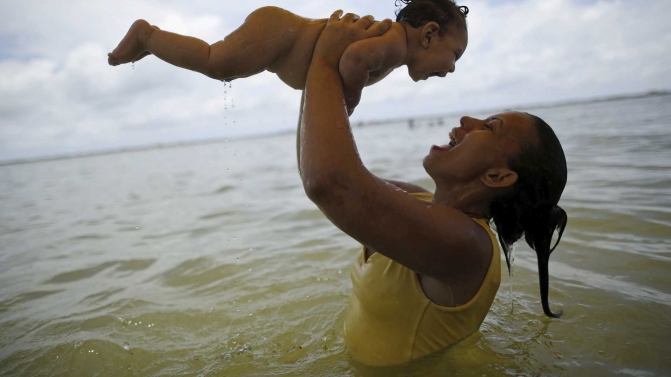Alves holds her daughter in Olinda