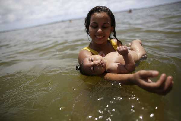 Rosana Vieira Alves holds her 4-month-old daughter Luana Vieira, who was born with microcephaly, in the sea in Olinda