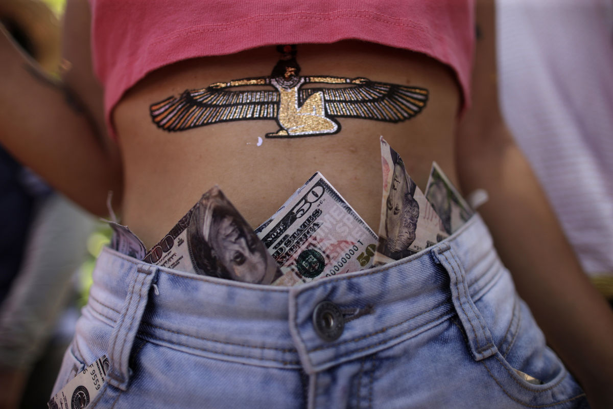 A reveller is seen with dollar bills tucked behind waistband of jeans during an annual block party in Olinda