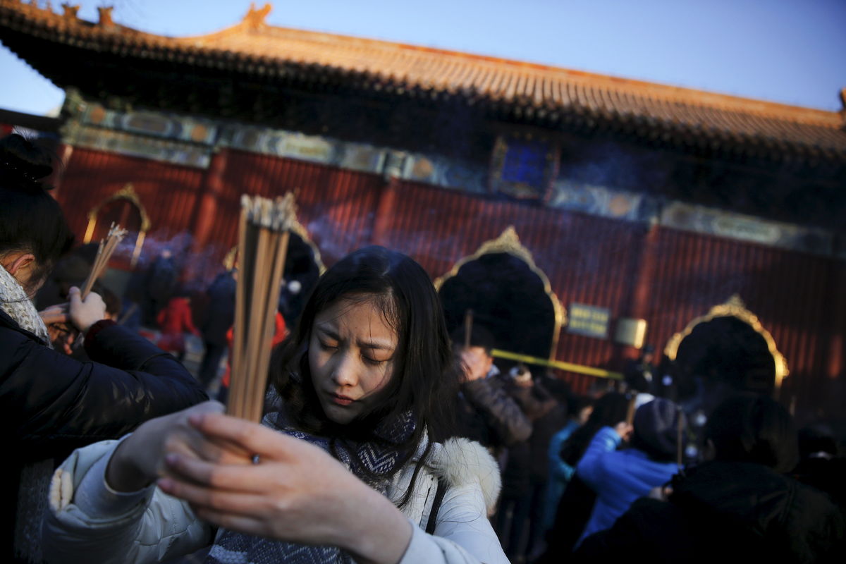 People burn incense and pray for good fortune on the first day of the Lunar New Year of the Monkey at Yonghegong Lama Temple in Beijing