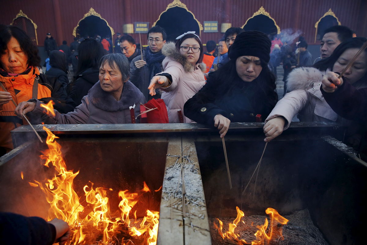 People burn incense and pray for good fortune on the first day of the Lunar New Year of the Monkey at Yonghegong Lama Temple in Beijing