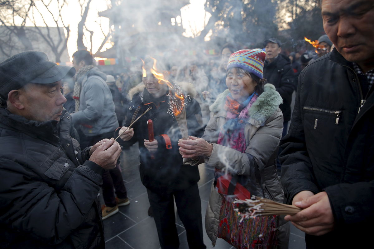 Pessoas queimam incenso e rezam para ter sorte e fortuna no primeiro dia do ano novo chinês (REUTERS/Damir Sagolj)