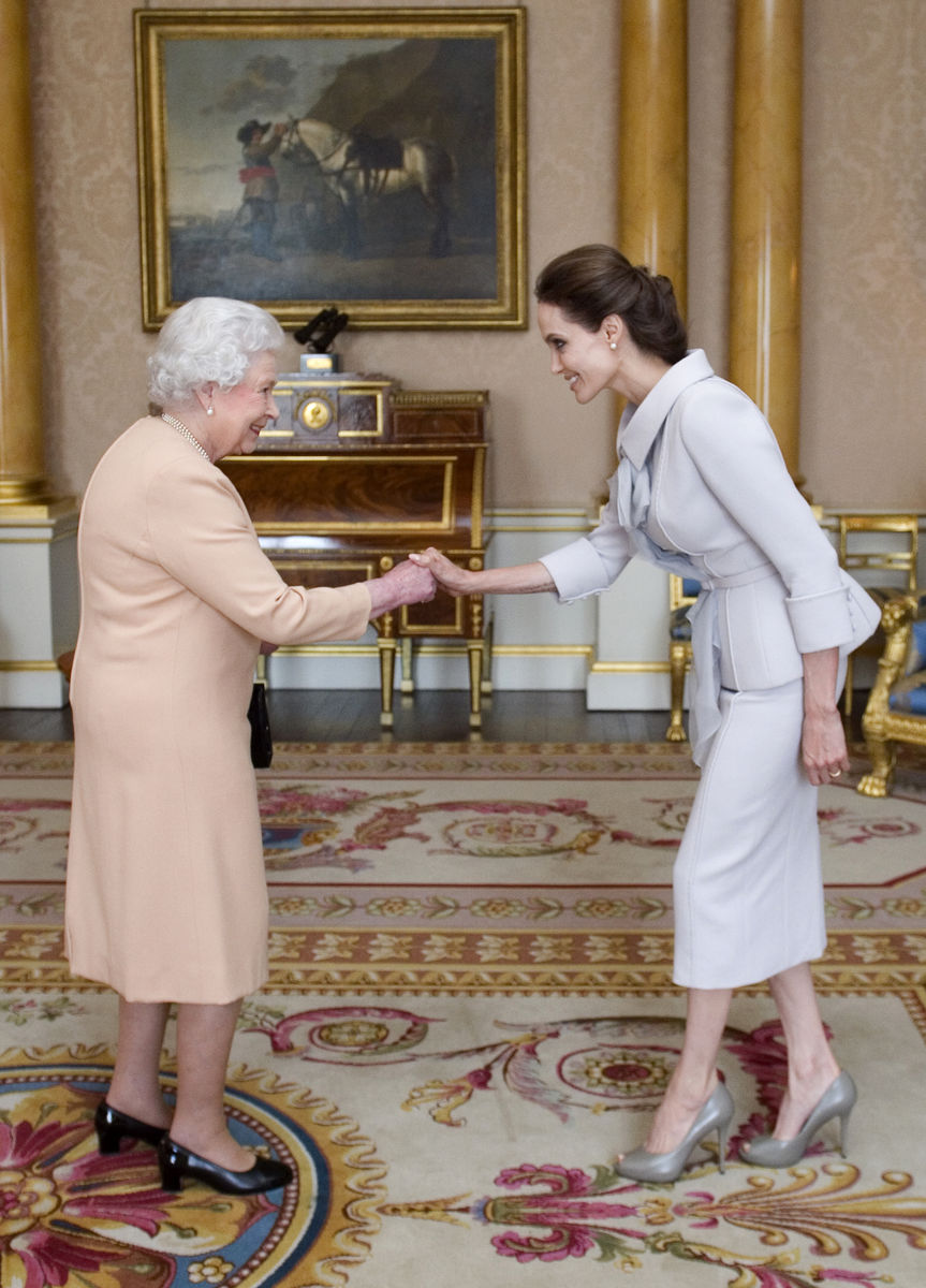 Actress Angelina Jolie is greeted by Britain’s Queen Elizabeth before being presented with the Insignia of an Honorary Dame Grand Cross of the Most Distinguished Order of St Michael and St George in London