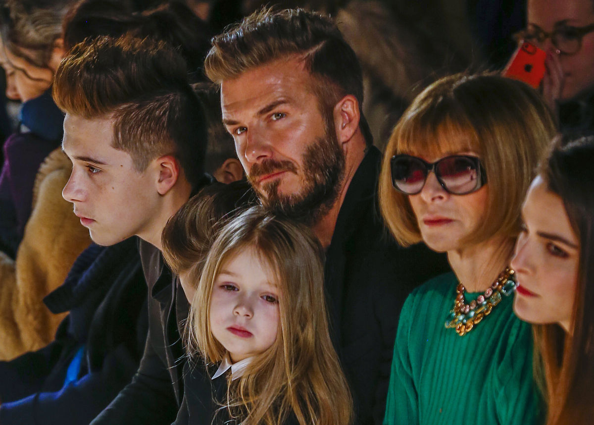 David Beckham sits next to Vogue editor Anna Wintour  with his daughter, Harper,  and son Brooklyn during New York Fashion Week