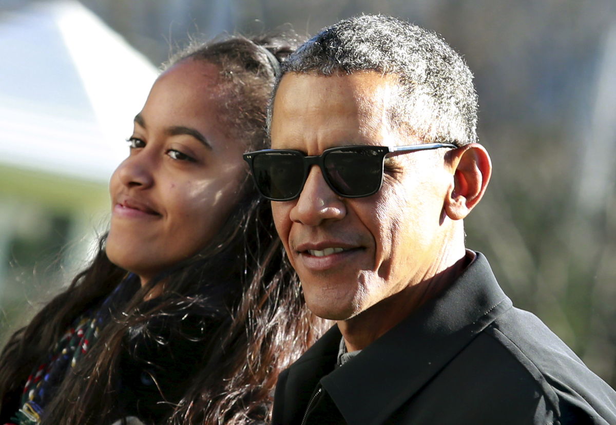 President Barack Obama walks with his daughter Malia on the South Lawn of the White House