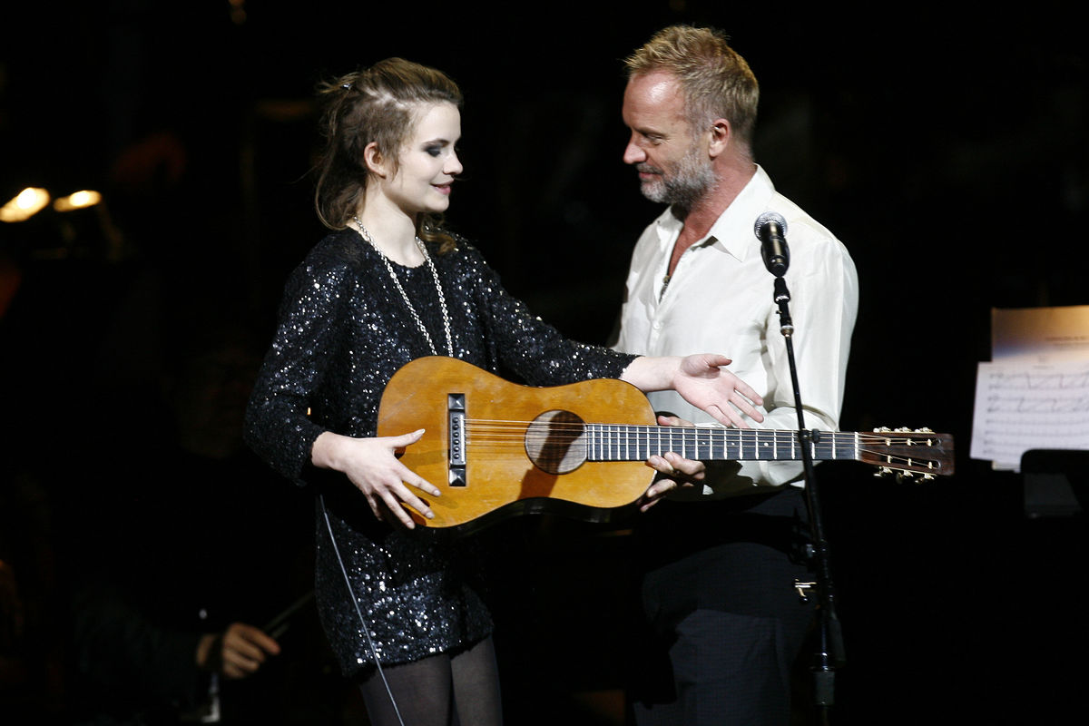 Singer Sting gives his favourite guitar to his daughter Coco Sumner as she performs during the Rainforest Foundation Benefit Concert in New York