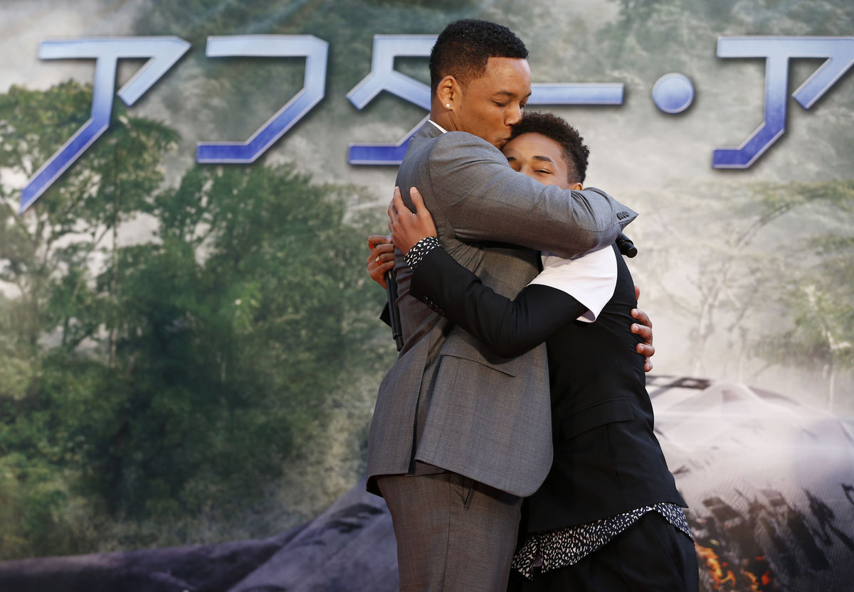 U.S. actor Will Smith and his son Jaden Smith hug each other during a promotional event for their movie “After Earth” in Tokyo