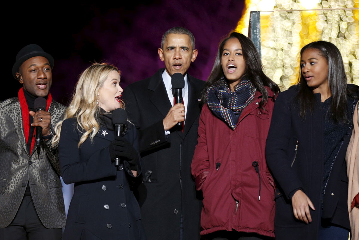 U.S. President Obama sings carols along with singer Blacc, actress Witherspoon and his daughters during the National Christmas Tree Lighting and Pageant of Peace ceremony in Washington