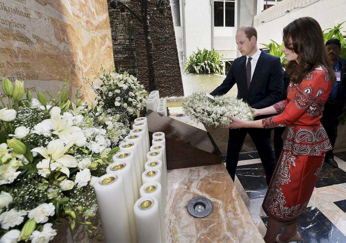 Britain’s Prince William and his wife Catherine, Duchess of Cambridge, hold a wreath as they pay their respects at the 26/11 memorial at the Taj Mahal Palace hotel, one of the sites of the 2008 attacks, in Mumbai, India