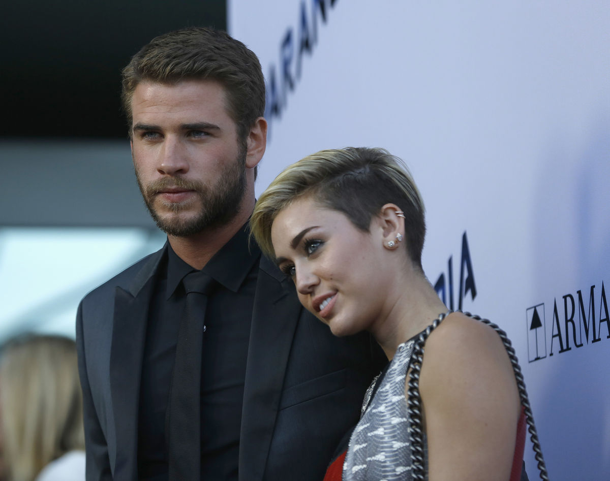 Hemsworth poses with Cyrus at premiere of 