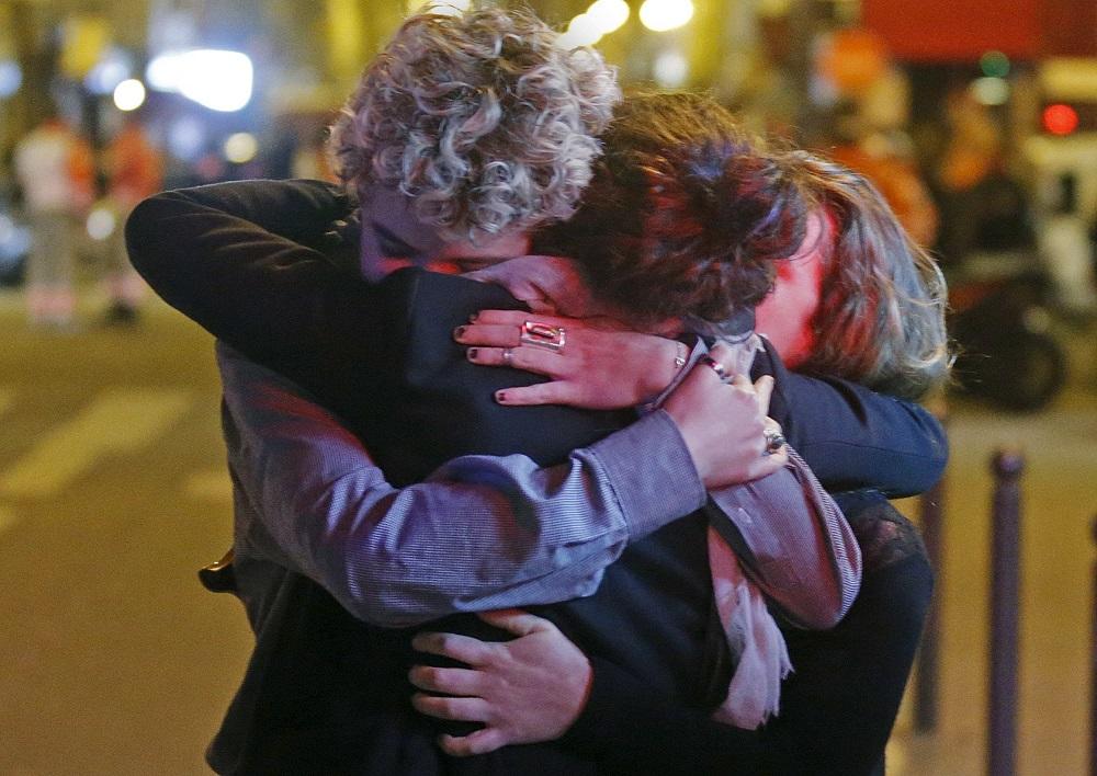 People hug on the street near the Bataclan concert hall following fatal attacks in Paris, France,