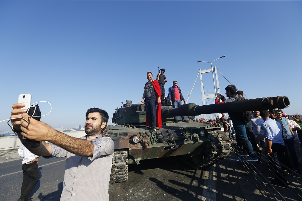 A man takes a selfie in front of a tank after troops involved in the coup surrendered on the Bosphorus Bridge in Istanbul