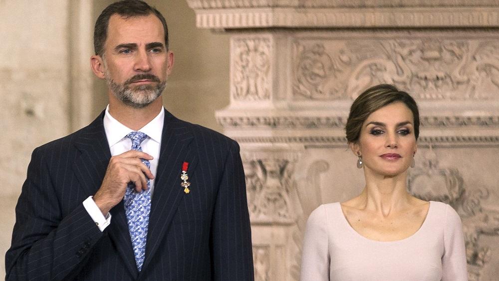 Spain's King Felipe adjusts his tie next to Queen Letizia during a ceremony at the Royal Palace in Madrid