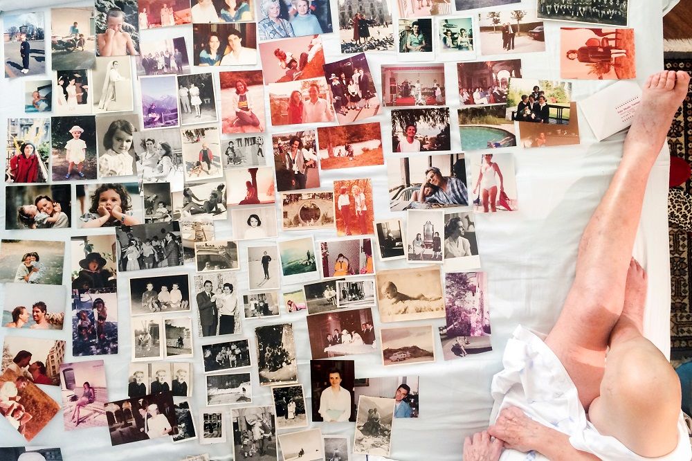 Fotografias antigas de família espalhadas na cama de Marisa Vescos, enquanto ela e a neta, a fotógrafa Gaia Squarci, autora destas imagens que retratam os últimos dias da avó que sofre de um cancro incurável, organizam um álbum (Foto: REUTERS/Gaia Squarci)