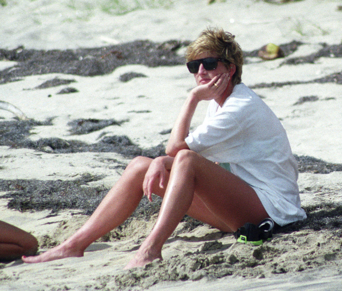 Princess Diana relaxes on the sand during a visit to the beach on the Caribbean Island of Nevis