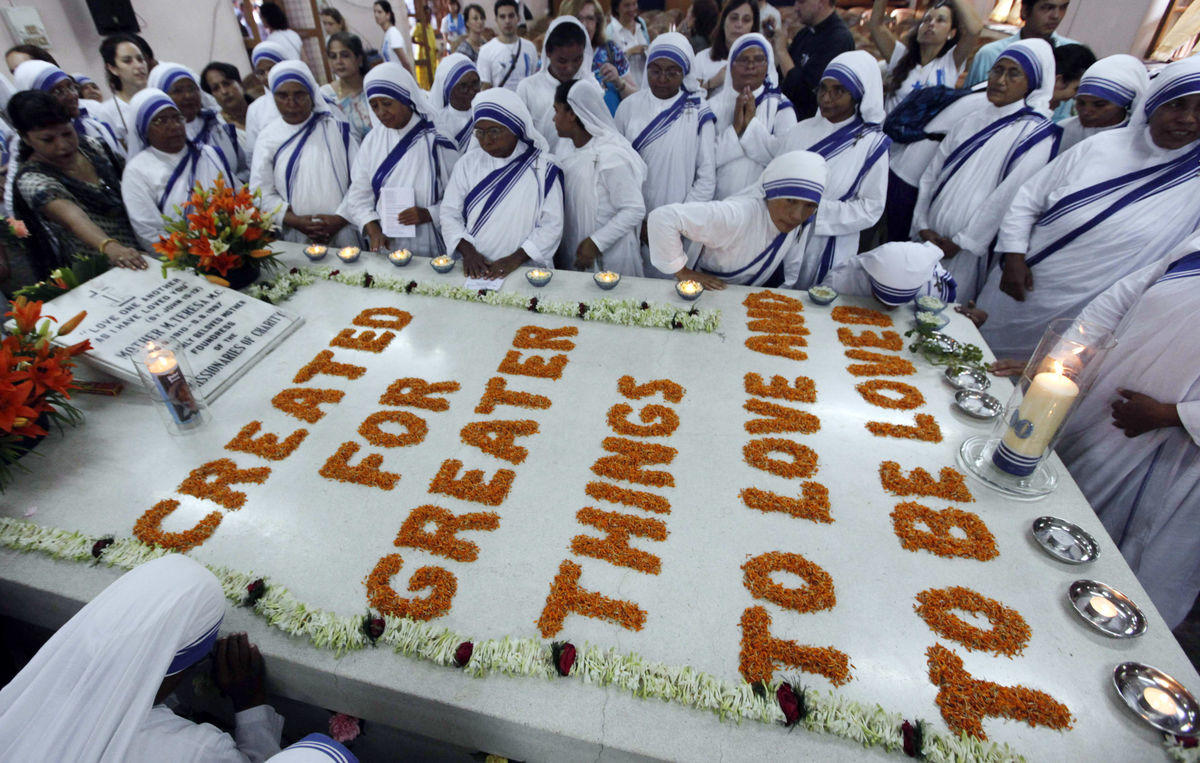 Catholic nuns from the Missionaries of Charity pray beside Mother Teresa’s tomb on the occasion of her 100th birth anniversary in Kolkata