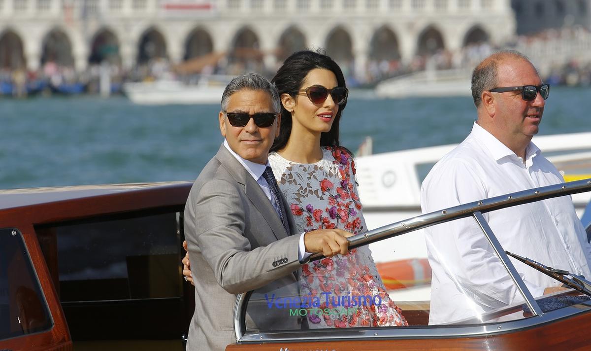 U.S. actor Clooney and his wife Alamuddin stand on a water taxi at the Grand Canal in Venice