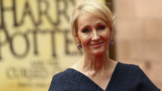 Author poses for photographers at a gala performance of the play Harry Potter and the Cursed Child parts One and Two in London