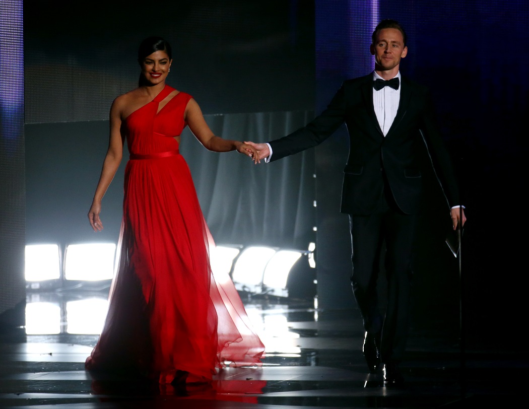 Actors Chopra and Hiddleston walk onstage to present an award at the 68th Primetime Emmy Awards in Los Angeles
