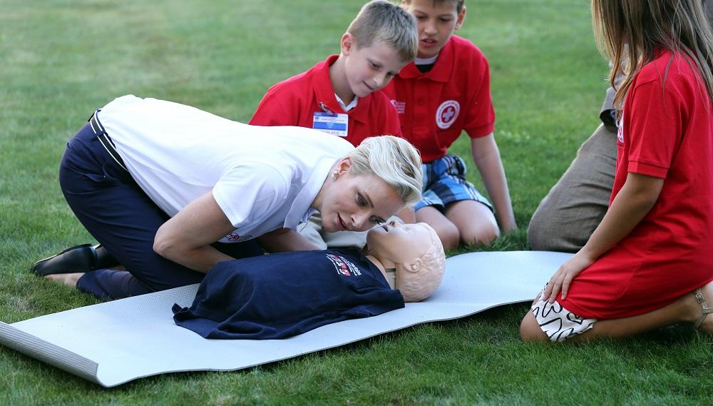 Monaco’s Princess Charlene, goodwill ambassador for the IFRC for first aid, demonstrates on a dummy how to practice first aid to chidren at the UN in Geneva