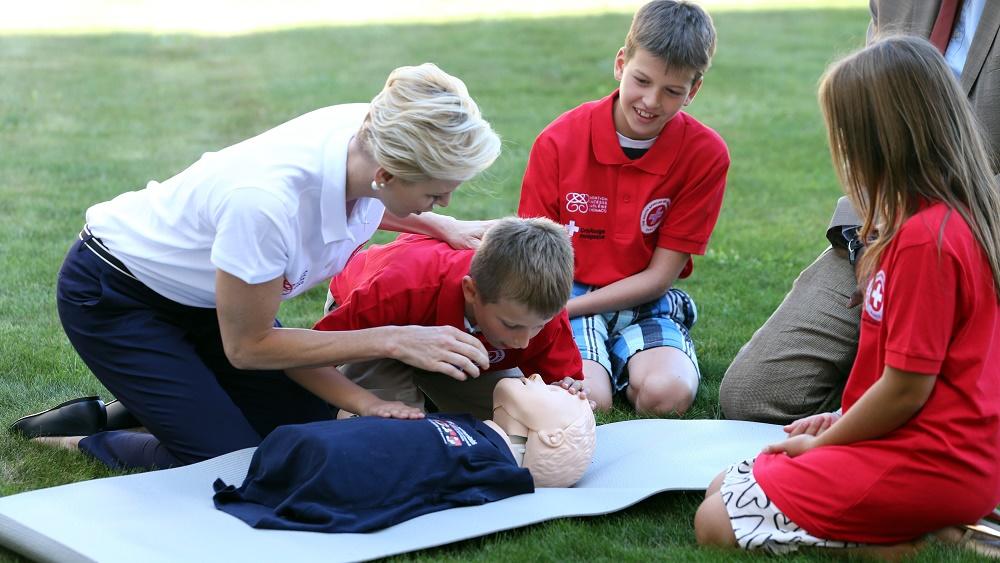 Monaco’s Princess Charlene, goodwill ambassador for the IFRC for first aid, demonstrates on a dummy how to practice first aid to chidren at the UN in Geneva