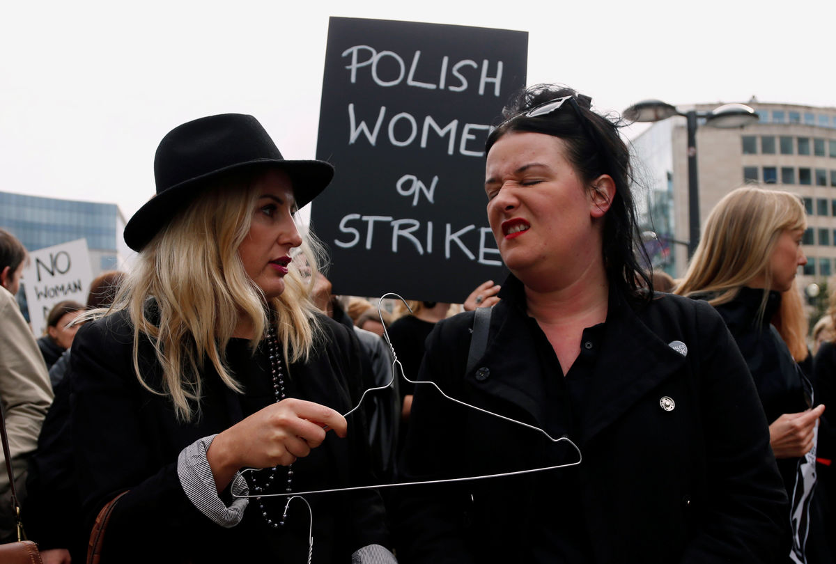 A demonstrator displays a hanger to protest against a proposed parliament bill to completely ban abortion in Poland, in front of EU institutions in Brussels
