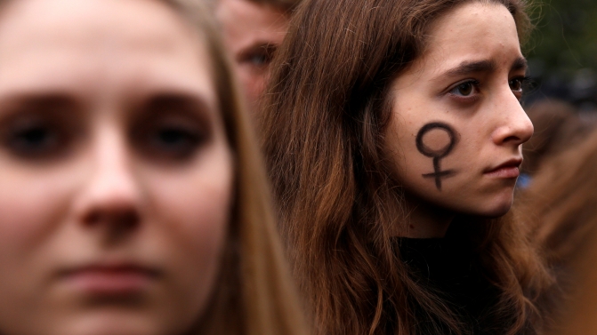 A woman looks on as people gather in an abortion rights campaigners’ demonstration to protest against plans for a total ban on abortion in front of the ruling party Law and Justice (PiS) headquarters in Warsaw