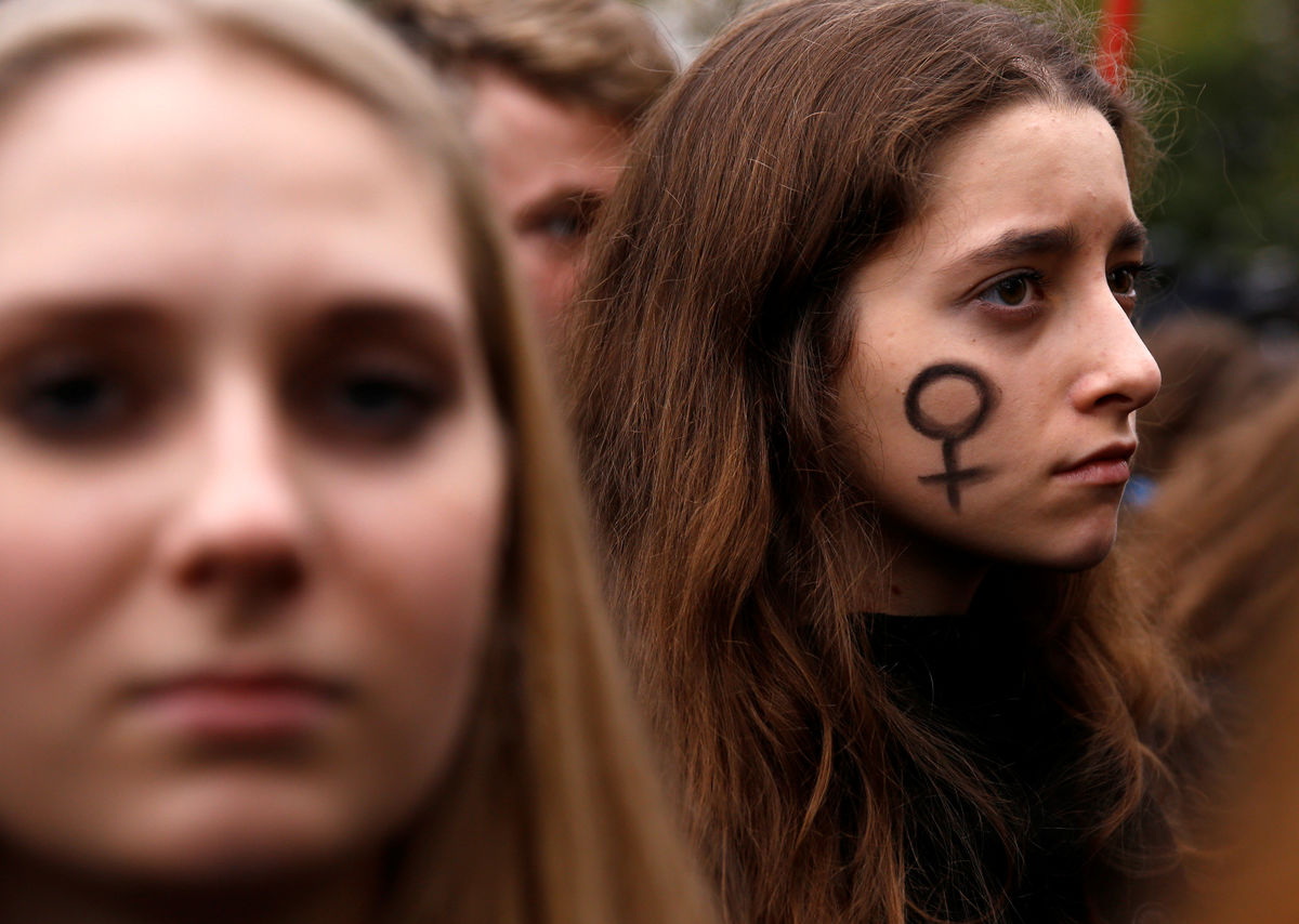 A woman looks on as people gather in an abortion rights campaigners’ demonstration to protest against plans for a total ban on abortion in front of the ruling party Law and Justice (PiS) headquarters in Warsaw