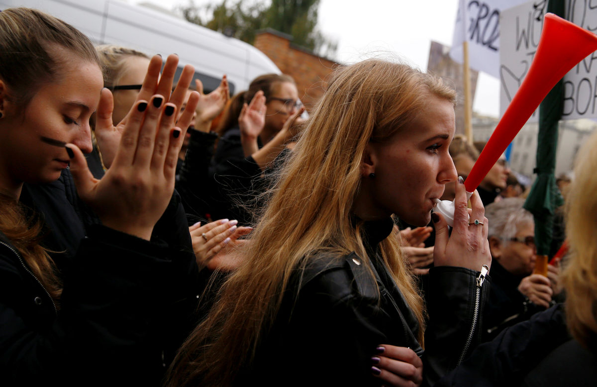 A woman blows a horn as she takes part in an abortion rights campaigners’ demonstration to protest against plans for a total ban on abortion in front of the ruling party Law and Justice (PiS) headquarters in Warsaw