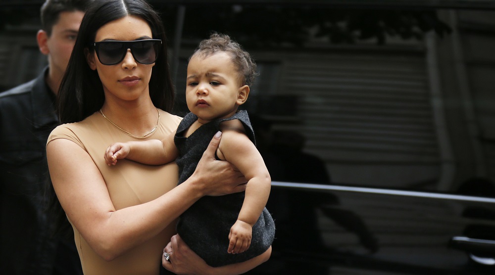 TV personality Kim Kardashian holds her daughter North in her arms as she shops in Paris