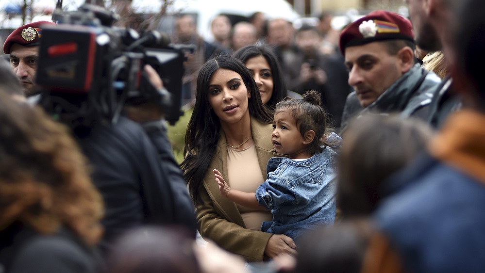 U.S. television personality Kim Kardashian (C) with her daughter North West in hand walks during their visit to Yot Verk Church in Gyumri