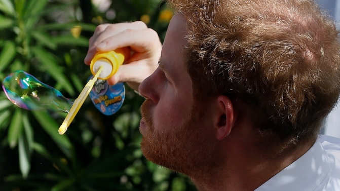 Prince Harry blows a bubble as he attends a charity event during his official visit in St. John’s