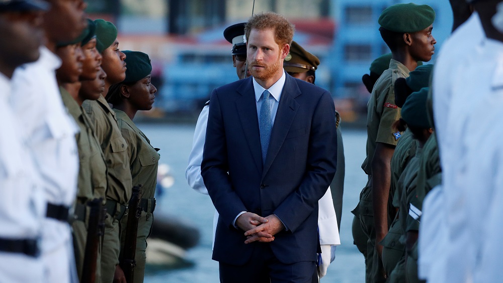 Britain’s Prince Harry inspects an honor guard during an official welcome ceremony on the dock in Pointe Seraphine, St. Lucia