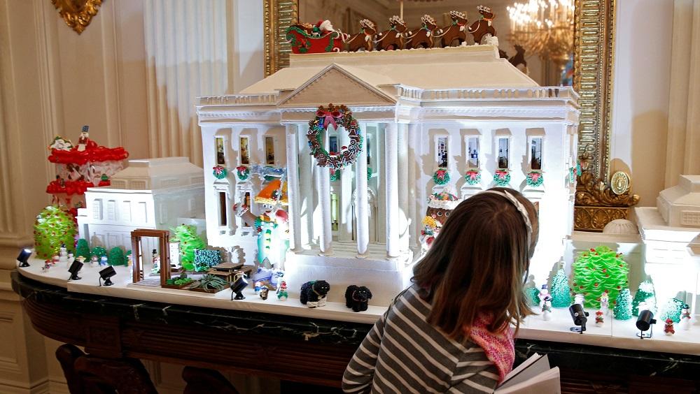A child looks at the gingerbread house in the State Dining Room during a holiday decor preview at the White House in Washington