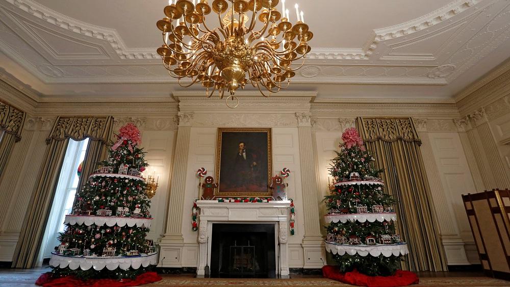 Christmas trees flank a painting of Abraham Lincoln at the State Dining Room during a preview of holiday decor at the White House in Washington