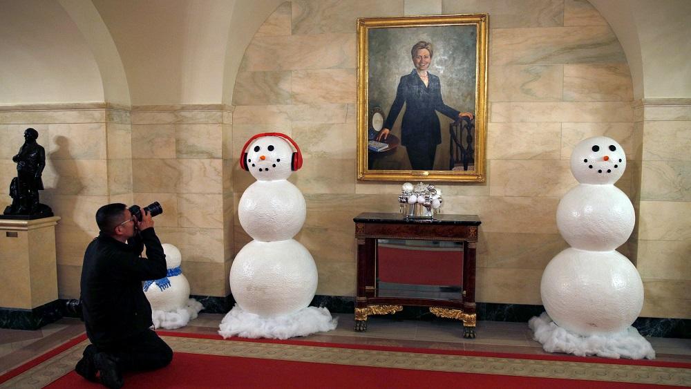 Snowmen flank a painting of former first lady Hillary Clinton during a holiday decor preview at the White House in Washington