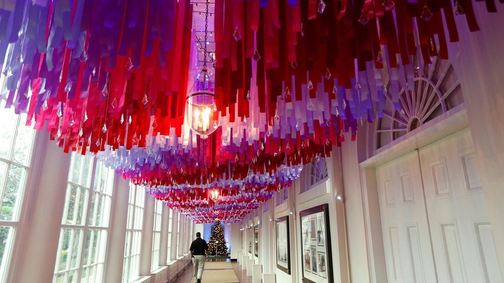 A man walks down the East Colonnade during a holiday decor preview at the White House in Washington