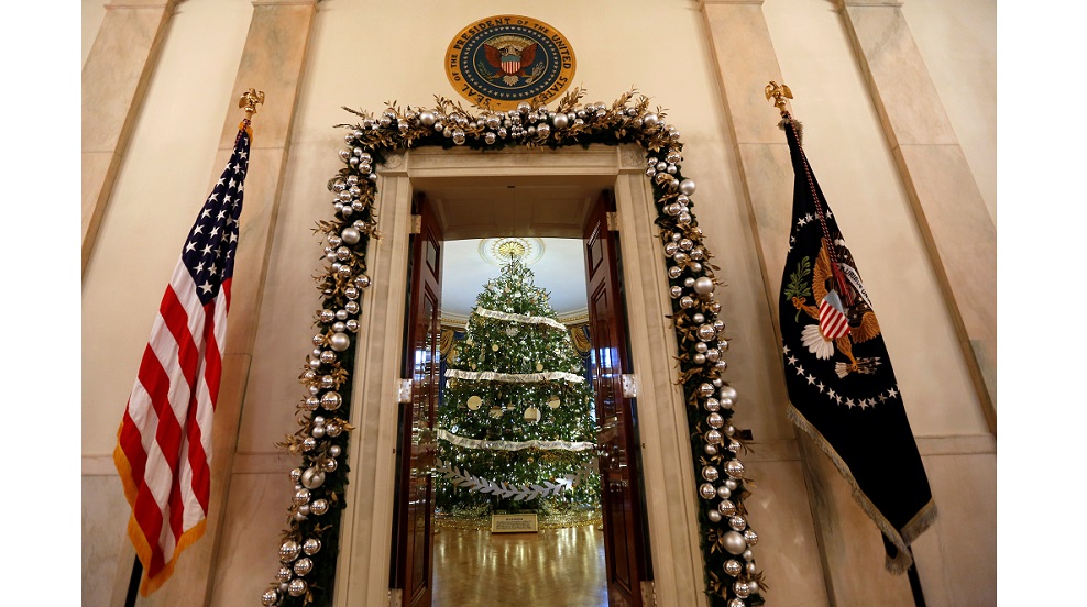 The White House Christmas Tree is seen through the doorway into the Blue Room during a preview of holiday decor at the White House in Washington