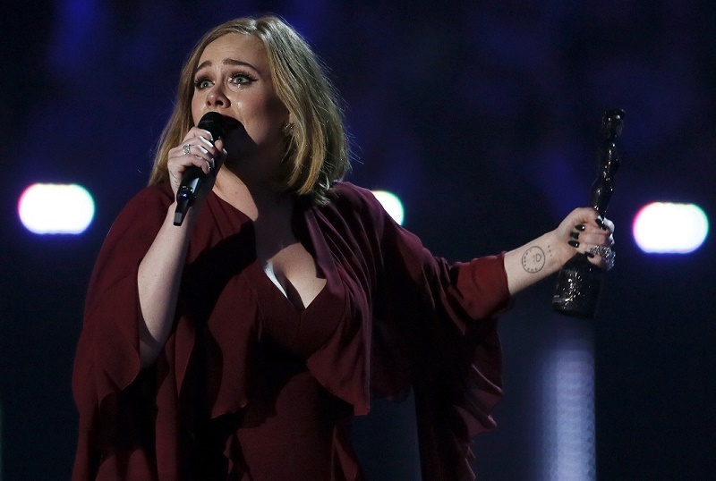 Adele reacts as she accepts the global success award at the BRIT Awards at the O2 arena in London