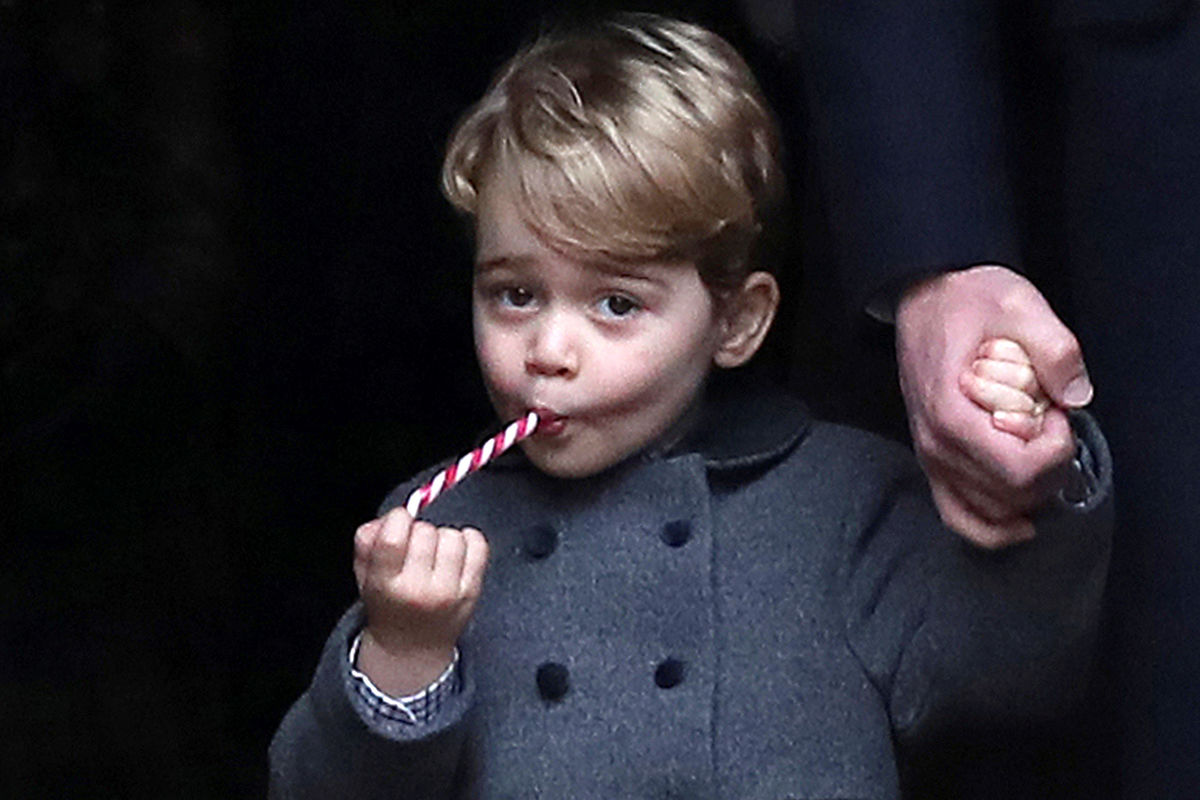 O príncipe George a comer um doce na manhã do dia de Natal, à chegada à Igreja de St Mark's, em Englefield