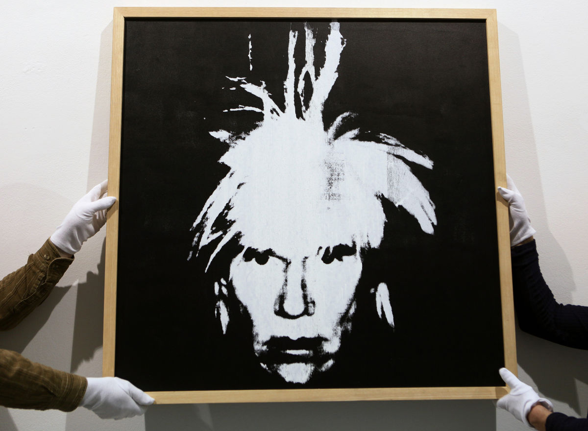 Workers adjust an autoportrait of Andy Warhol as they prepare the “Andy Warhol and Czechoslovakia” exhibition in central Prague